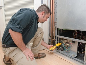 HVAC technician using a meter to check heat pump amperage